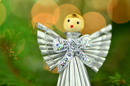 christmas decoration, silver angel made of straw against bokeh backgroundの写真素材