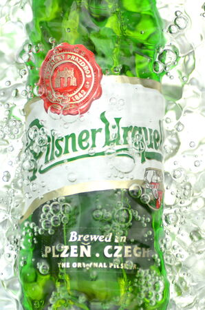 Pilsner Urquell pale lager beer in splashed water.のeditorial素材