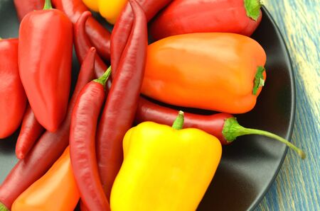 variety of different peppers on black plateの写真素材