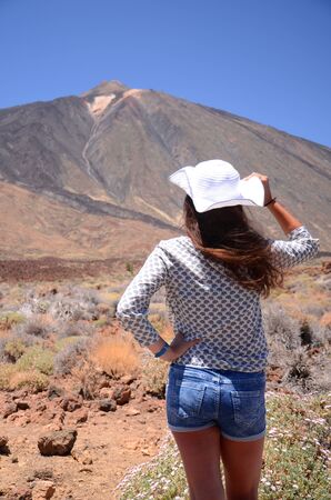 Attractive young brunette woman looking at volcano Teide on Tenerife, Spainの写真素材