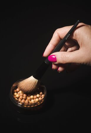 Avon glow bronzing pearls isolated on dark background.のeditorial素材