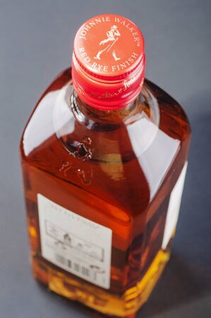 Johnnie Walker red rye finish blended whiskey on stone slate background. Johnnie Walker was established in 1820 in Kilmarnock, Scotlandのeditorial素材