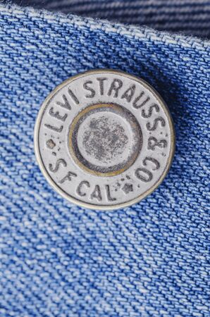 Closeup of Levi Strauss button on blue jeans