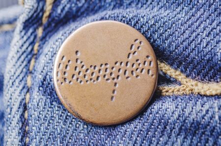 Closeup of Wrangler button on blue jeans.のeditorial素材
