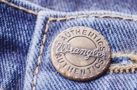 Closeup of Wrangler button on blue jeans.のeditorial素材