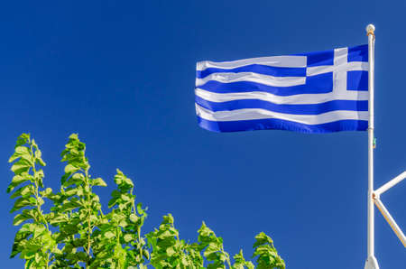 National flag of Greece waving against blue skyの写真素材