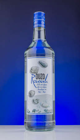 Bottle of Rousali ouzo isolated on gradient background. Ouzo is dry anise-flavored aperitif. Rousali ouzo has been produced by Rousali Bros SA since 1948, Greece.のeditorial素材