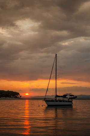 Dramatic rainy clouds during sunset over bay in Splitska on Brac island in Croatia.の写真素材