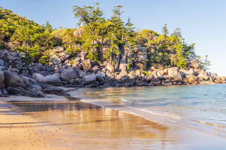 Picturesque golden sandy Arthur Beach with granite boulders and turquoise water on Magnetic Island, Queensland, Australia. It is a holiday destination 8 km offshore of Townsville.の写真素材