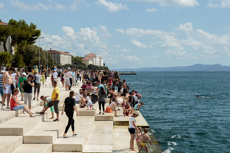 ZADAR, CROATIA - AUGUST 17, 2015: People relaxing and swimming at Zadar famoust Sea Organs. The sea organ won European Prize for Urban Public Space award in 2006.のeditorial素材