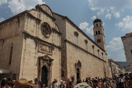 DUBROVNIK, CROATIA - AUGUST 13, 2015: Church of Holy Savior and Franciscan Monastery in city of Dubrovnik, Croatia, and tourists walking on Stradunのeditorial素材