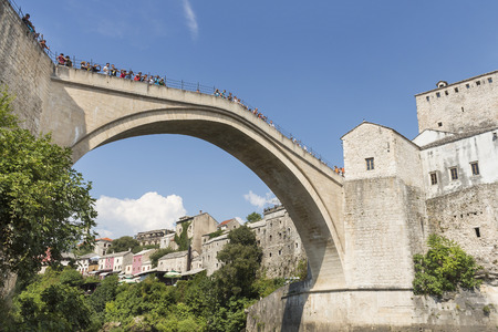 MOSTAR, BOSNIA AND HERZEGOVINA - AUGUST 05, 2015: Tourist and locals walking over Old bridge in Mostar.The bridge is included to the UNESCO heritageのeditorial素材