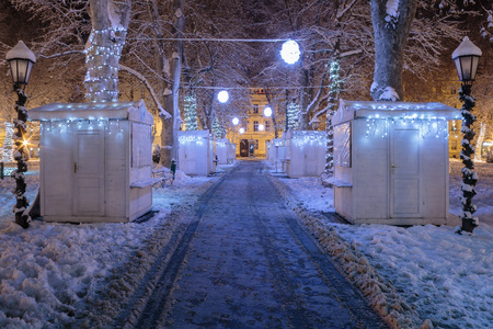 Zrinjevac park covered with snow in the cold winter night and closed stands on pathwayの写真素材