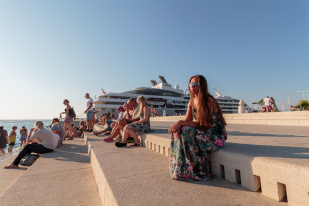 ZADAR, CROATIA - JULY 10, 2016: Young woman relaxing at Zadar famoust Sea Organs. The sea organ won European Prize for Urban Public Space award in 2006.のeditorial素材