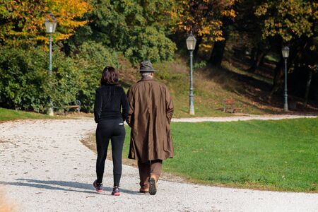 Elderly couple walking in the park in autumnの写真素材