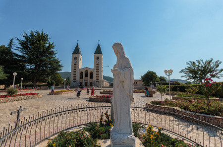 MEDUGORJE, BOSNIA AND HERZEGOVINA - JULY 12, 2016: Virgin Mary statue and the parish church of St. James, the shrine of Our Lady of Medugorjeのeditorial素材
