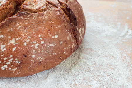 Rye bread on a wooden board sprinkled with flour