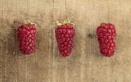 Tayberry a hybrid of raspberries and blackberries on wooden tableの写真素材