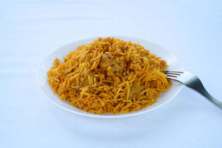 Biryani with chicken on white. A pilaf-like dish of rice, vegetables and chicken. Arabic, Pakistani and Indian cuisines. Side view. Eye levelの写真素材