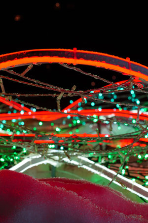 New Year, Christmas multi-colored festive illumination lights up the snow at night. Electric LED garlands on the footpath, road. Vertical greeting card template, copy space on top.の写真素材