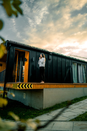 Young woman stands on nails on the terrace near the house early in the morning. Sadhu boards. Nail conceptの写真素材
