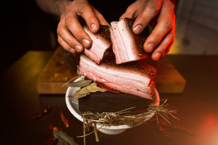 Smoked lard with meat on fire in a plate on a black background. Ukrainian cuisine concept. boiled pork.lard on smoke.Grilled lardの写真素材