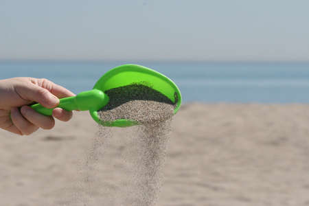 Shoveling sand on the beach at Lake Ontario.の写真素材