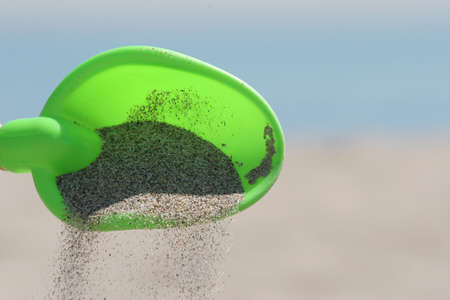 Scooping sand at the beachの写真素材