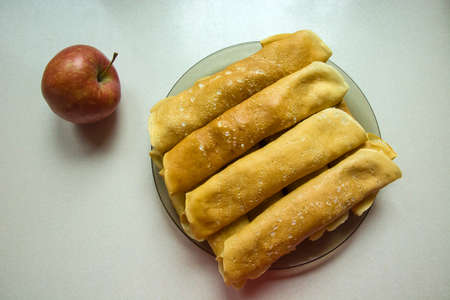 Fried pancakes on a plate and an appleの写真素材