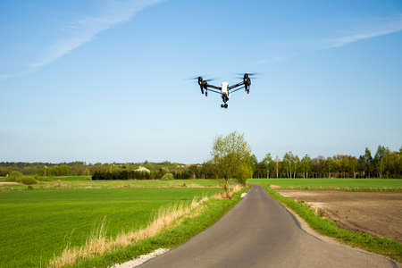 Drone flying over road and fields