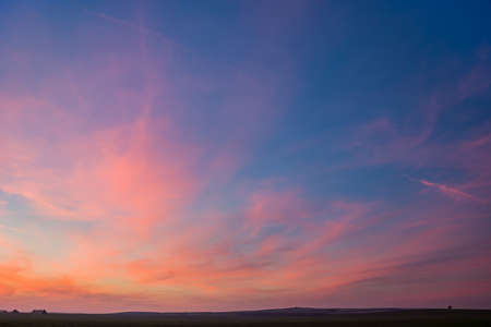 Pink clouds on blue sky after sunset