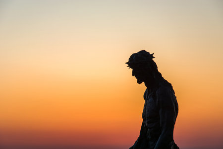 Chelm, Lubelskie, Poland - May 30, 2018: A statue of Jesus against the sky at colorful sunsetのeditorial素材
