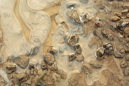 Frozen water, mud and stones, winter viewの写真素材