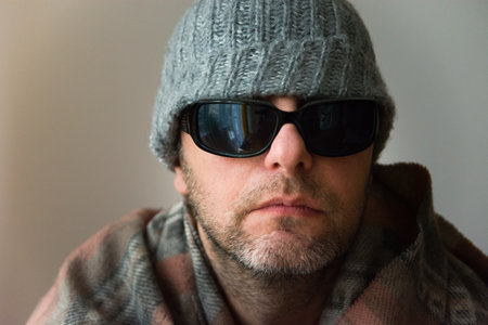 A man with a beard with glasses and a winter hat, portrait