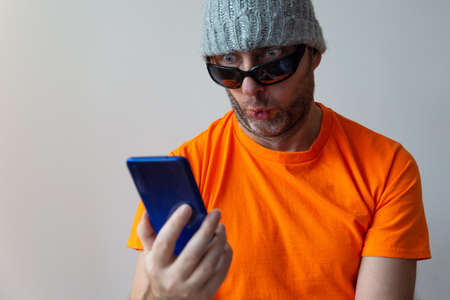 Man with a smartphone in his hand with a puzzled look