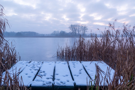 Snow on a wooden pier by a frozen lake, Stankow, Lubelskie, Polandの写真素材