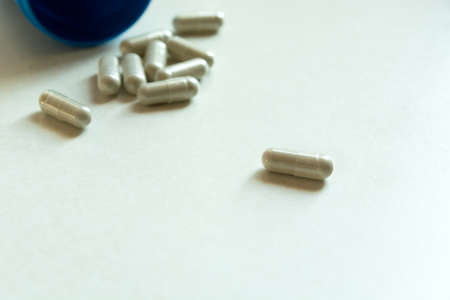 Close up of pills in capsules on a white countertopの写真素材