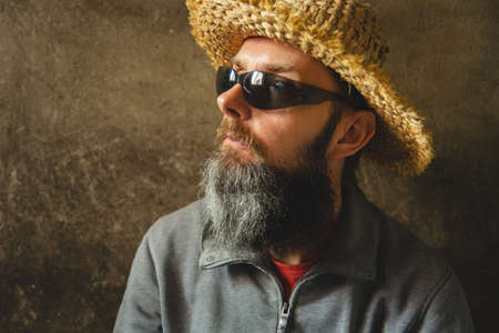 A man with a long beard in a straw hat, male portraitの写真素材