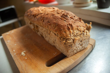 Home-baked loaf of bread on a wooden board in kitchen