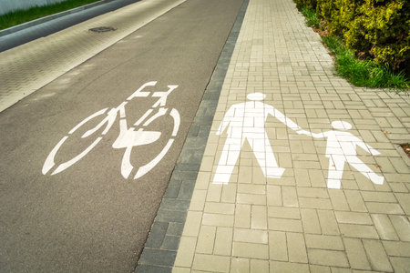A bike path and a sidewalk with painted white road pictograms, Chelm, Polandの写真素材