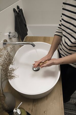 COVID-19 Coronavirus. Woman washing hands with foam soap and hot water at bathroom. Hygiene, preventing coronavirus. Corona Virus pandemic protection by cleaning hands frequently.の写真素材