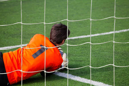Goalkeeper catching a ball in the fall の写真素材