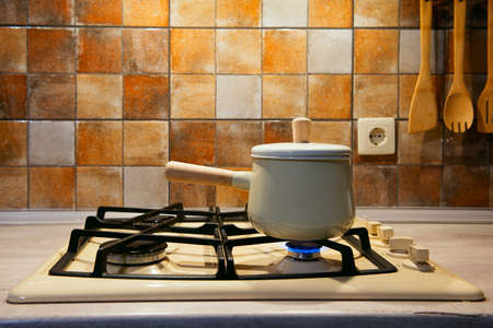 New pan with wooden handle on the stove. On fireの写真素材