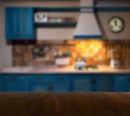 Wood table top and blurred kitchen interior background with vintage filter - can used for display or montage your products.の写真素材