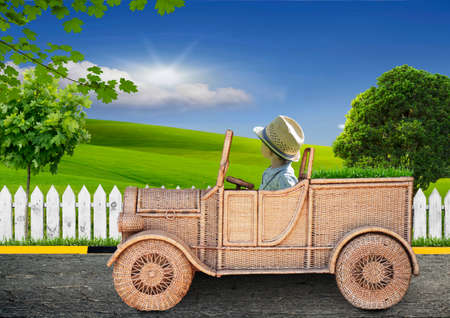 small child on a toy car looking at the fieldの写真素材