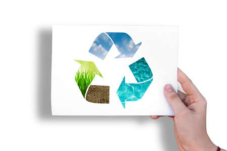 Ecology sign on white sheet on grass background in hand