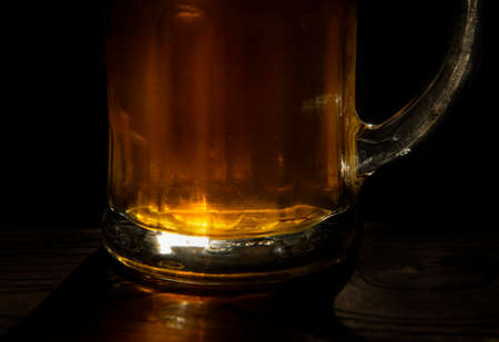 A glass of fresh, cold beer close-up on a black backgroundの写真素材