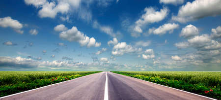 green field and road over blue sky 