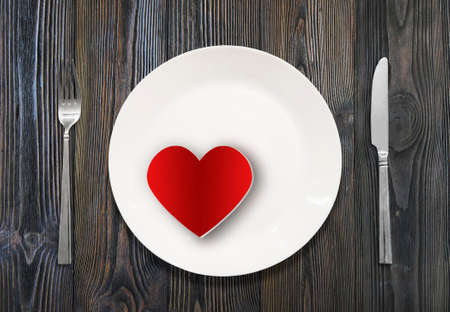 white plate, knife, fork, on a background of woodの写真素材