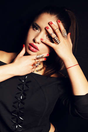 fashion studio photo of beautiful young woman with dark hair with evening makeup and a lot of accessoriesの写真素材